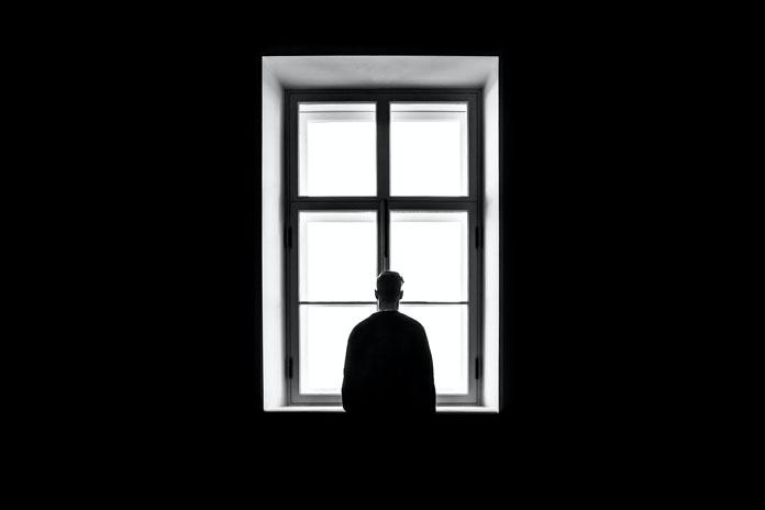 Slika na kojoj čovek stoji ispred prozora. Slikao Sasha Freemind.